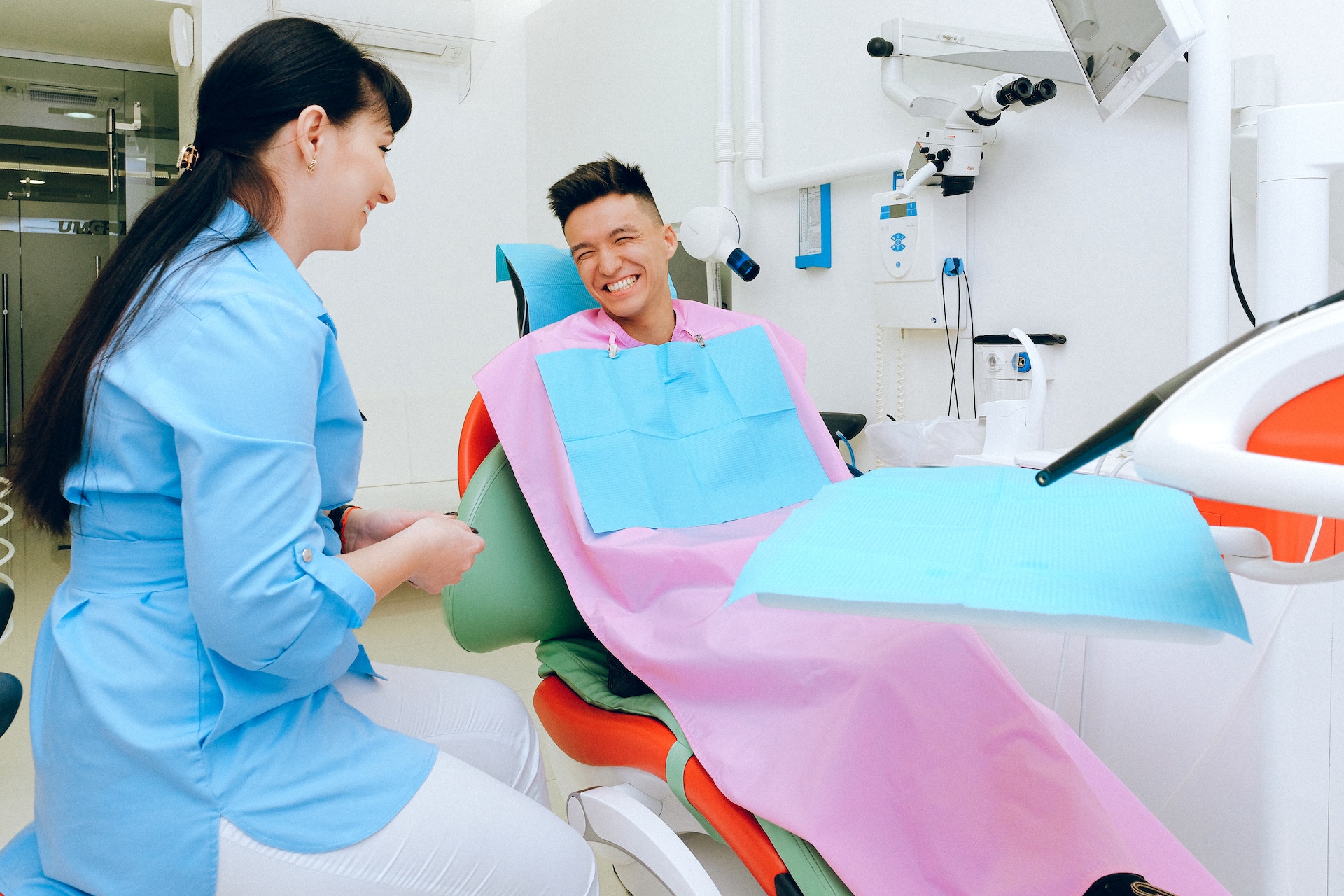 A picture of a dentist and a patient with a happy smile.