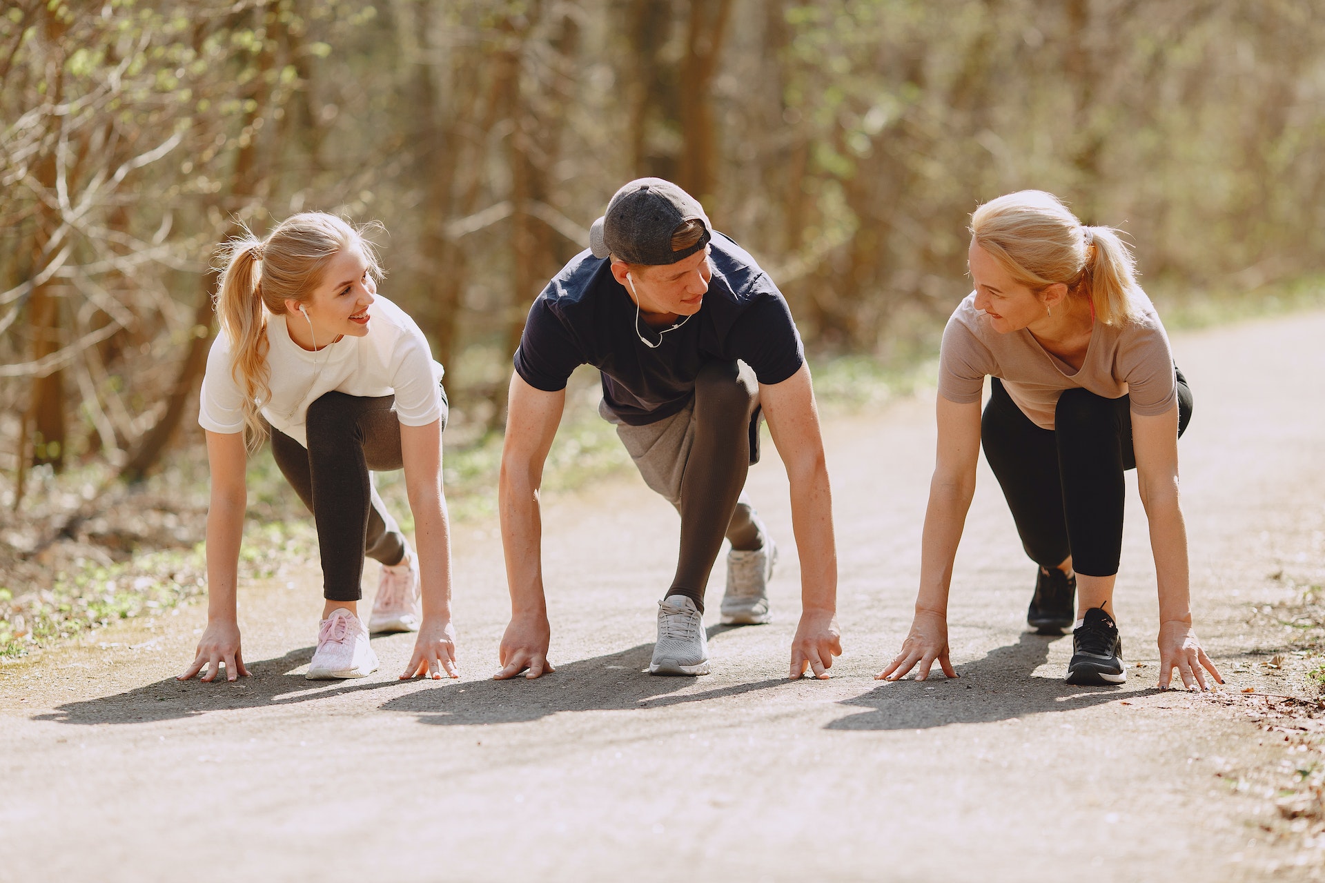 Three people stretching for a run in the park